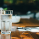 lone water glass on table on sunny day